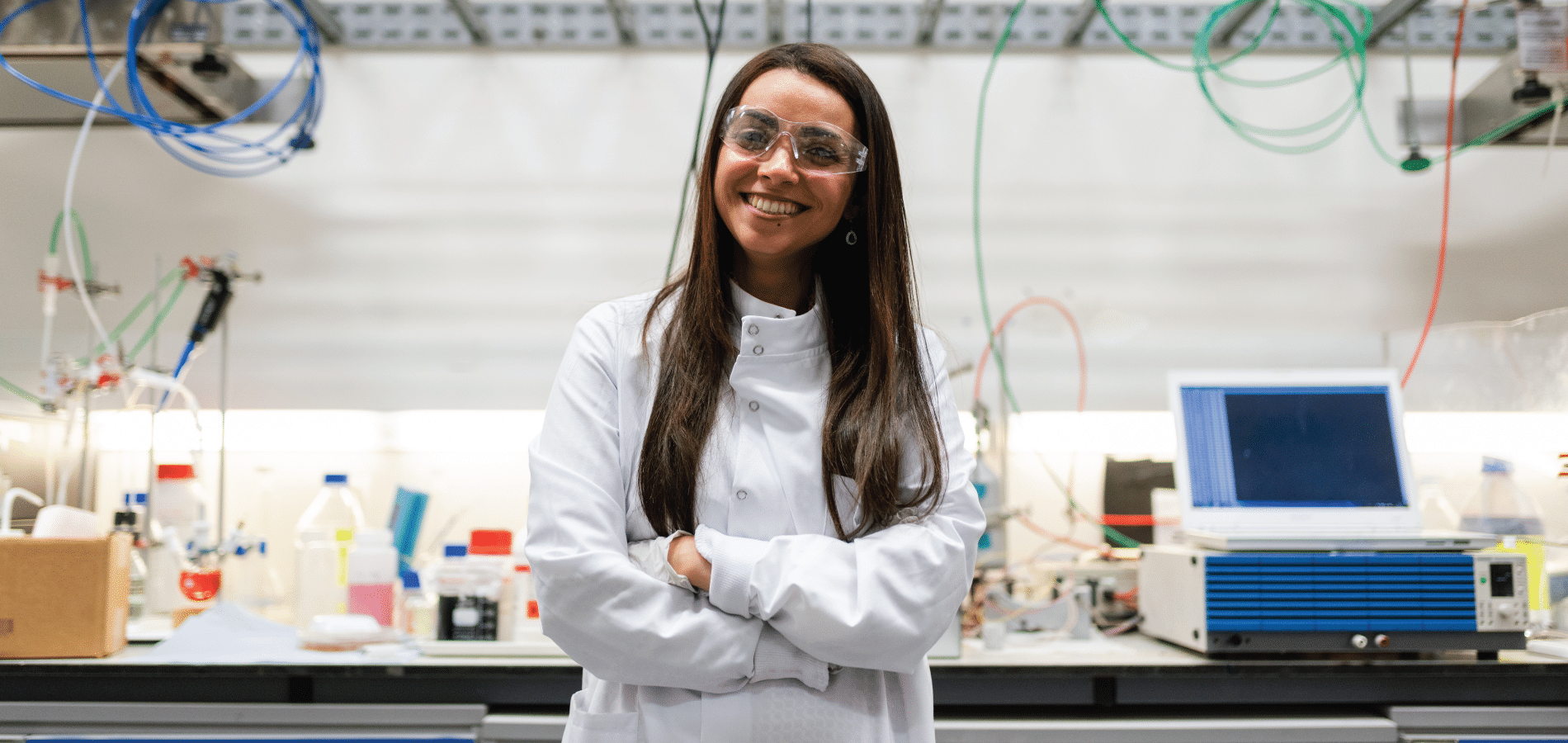 female lab technician wearing safety glasses and smiling