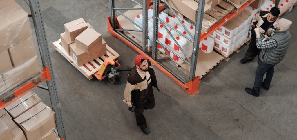 light industrial employee pulling cart of goods throughout a warehouse