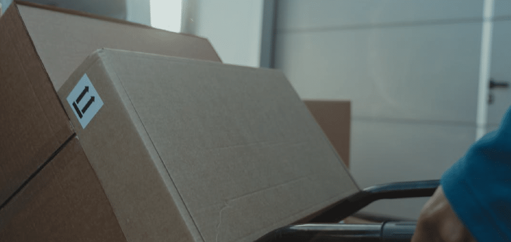 multiple shipping boxes stacked on a rolling cart