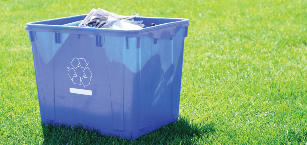 corrugated plastic recycling bin sitting on green grass